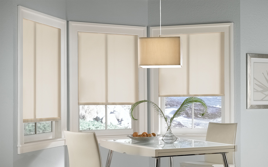 Quality window shades meet modern interior design at Sunburst Shutters Atlanta. Roller shades in modern white kitchen.