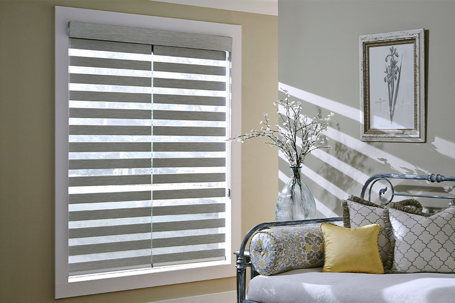 Find Functional and stylish window blinds for Atlanta homes at Sunburst. Gray blinds on a large window next to a couch.