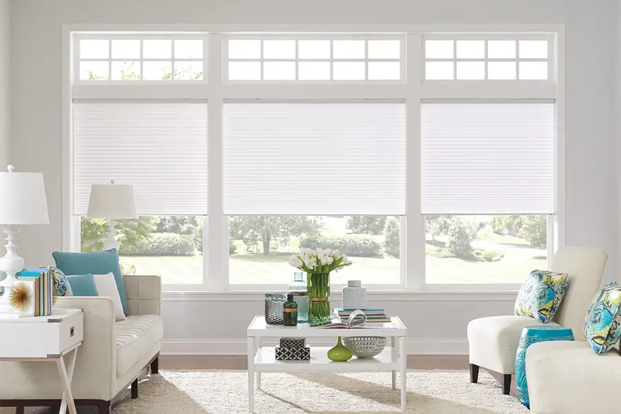 Insulating cellular shades can help keep cold air and hot UV rays from entering your Atlanta home. White cellular shades on windows in a white living room